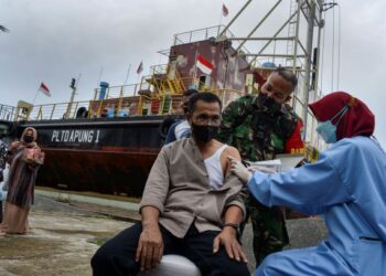 SEORANG penduduk menerima suntikan vaksin Covid-19 di Banda Aceh, Indonesia. - AFP