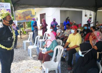 ADHIF Syan Abdullah memberi ucapan kepada penduduk Kampung Orang Asli Bukit Tadom yang sudah diberi vaksin dalam. - UTUSAN / ABDUL RAZAK IDRIS