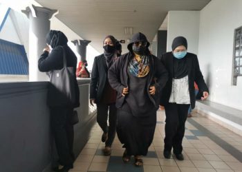 HAFIZAWATI Ahmad (tengah) diiringi pegawai SPRM selepas didakwa di Mahkamah Sesyen di Kompleks Mahkamah Ayer Keroh, Melaka, hari ini.  -UTUSAN/ DIYANATUL ATIQAH ZAKARYA