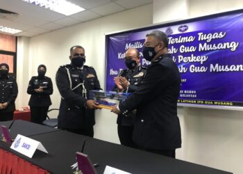 MOHD. Taufik Maidin menyerahkan tongkat kuasa sebagai simbolik penyerahan tugas kepada pemangkunya, Sik Choon Foo (kanan) sambil disaksikan Shafien Mamat (tengah) di IPD Gua Musang, Kelantan, hari ini. 