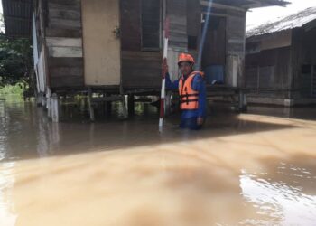 ANGGOTA APM memantau paras air di kawasan yang dilanda banjir di Pendang,  hari ini.