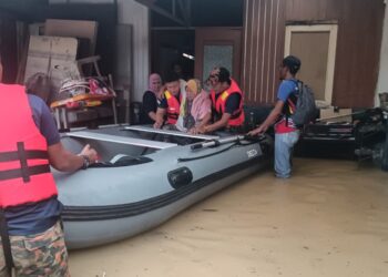 BEBERAPA anggota bomba sedang memindahkan seorang warga emas yang terperangkap dalam banjir kilat di Kampung Idaman, Klang, Selangor.-UTUSAN/ MOHAMAD NAUFAL MOHAMAD IDRIS