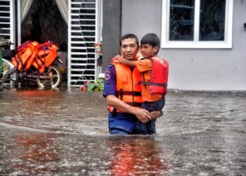 ANGGOTA  Angkatan Pertahanan Awam Malaysia membantu seorang kanak-kanak berpindah selepas rumahnya dinaiki air di Tok Jembal, Kuala Nerus, Terengganu, hari ini.