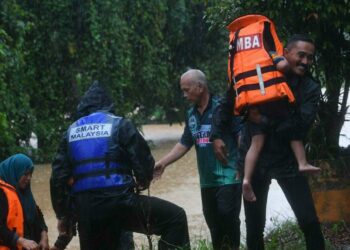 ANGGOTA bomba membantu memindahkan mangsa banjir di Kampung Kepah, Kuala Berang, Hulu Terengganu, hari ini. - UTUSAN/PUQTRA HAIRRY ROSLI