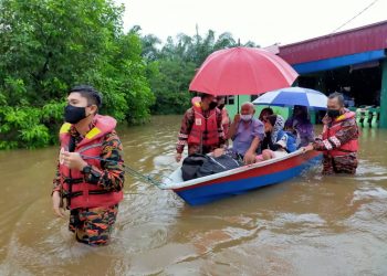 ANGGOTA bomba daripada Balai Bomba dan Penyelamat (BBP) Endau membantu memindahkan beberapa penduduk di Kampung Sungai Padang, Endau, Mersing, Johor.