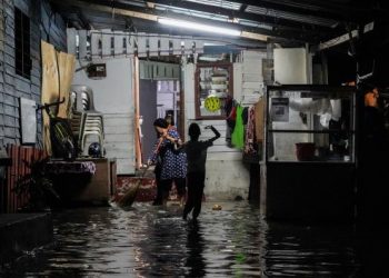 PENDUDUK bertungkus-lumus membersihkan kawasan rumah yang dinaiki banjir kilat di Kampung Baru, Kuala Lumpur. - UTUSAN/SHIDDIEQIIN ZON