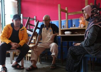 MUHAMMAD Noor Azman (kiri) ketika menyantuni beberapa mangsa banjir Meru di PPS SMK Sungai Binjai, Klang, Selangor.-UTUSAN/ MOHAMAD NAUFAL MOHAMAD IDRIS