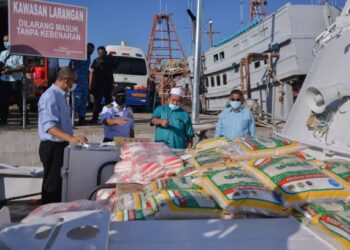 HANAFIAH Mat (kanan) bersama Zuhami Omar (kiri) melihat bekalan makanan yang dihantar ke Pulau Redang di jeti Agensi Maritim Malaysia di Kuala Terengganu, Terengganu hari ini. -  FOTO/PUQTRA HAIRRY ROSLI