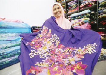 SITI Noor Aini Yusoff menunjukkan antara kain batik canting yang dihasilkannya di Kota Bharu, Kelantan.