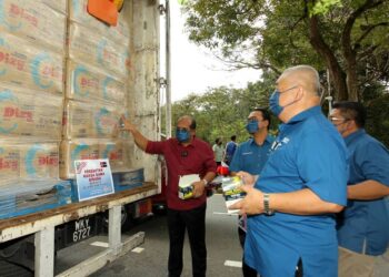 RASMAN Ithnain (kiri) melihat barang keperluan yang disumbang Bersatu Johor kepada pelajar dan kakitangan UTM yang menjalani PKPD di UTM Skudai, Johor Bahru di Johor.