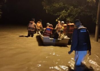 ANGGOTA Balai Bomba dan Penyelamat (BBP) Penawar membantu memindahkan mangsa banjir Kampung Baru Sungai, Bandar Penawar, Kota Tinggi. IHSAN BOMBA JOHOR