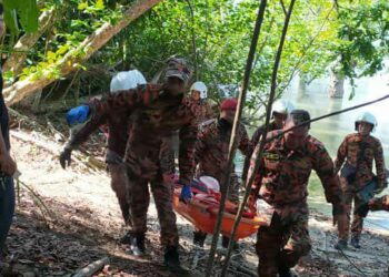 ANGGOTA BBP Endau mengusung seorang wanita yang terjatuh ke dalam gaung ketika mendaki di Pulau Mawar, Tanjung Resang, Endau di Mersing, Johor. -IHSAN BOMBA