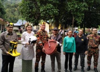 AZMI Osman (dua dari kanan) menyerahkan kelengkapan kebombaan kepada anggota PBS Orang Asli Ulu Geruntum di Dewan Orang Ramai Ulu Geruntum, Gopeng hari ini. - UTUSAN/ASLIZA MUSA