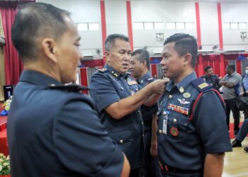 AZMI Osman (tengah) memakaikan pangkat kepada Shahrul Nizam Murad pada Majlis Perhimpunan Bulanan JBPM Perak di Bandar Meru Raya di Ipoh hari ini.  -UTUSAN/MUHAMAD NAZREEN SYAH MUSTHAFA