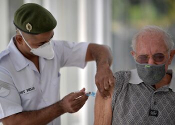 PEGAWAI perubatan dari angkatan tentera Brazil menyuntik vaksin kepada seorang warga emas yang berusia lebih dari 89 tahun Belo Horizonte, Minas Gerais, Brazil - AFP