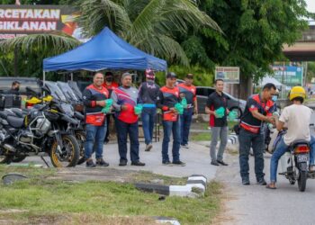 JUNAIDI Che Omar dan Mohd. Azam Hasan mengagihkan bubur lambuk kepada pengguna jalan raya di Jalan Langgar, Alor Setar, semalam. – MINGGUAN/SHAHIR NOORDIN