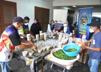 SEBAHAGIAN kariah dan penduduk tempatan membantu menyediakan bahan untuk membuat bubur lambuk pada Program Kongsi Berkat Bubur Lambuk anjuran EB Frozen Food Sdn. Bhd. (EB) dan Media Mulia Sdn. Bhd. di Masjid Mua'dz bin Jabal, Taman Setiawangsa, Kuala Lumpur, semalam. -UTUSAN/AMIR KHALID