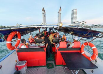 Pengunjung mencuba kelainan dengan menikmati juadah berbuka puasa di atas bot sambil menikmati menyusuri Sungai Terengganu dan bergambar di Jambatan Angkat Kuala Terengganu, semalam. - UTUSAN/PUQTRA HAIRRY