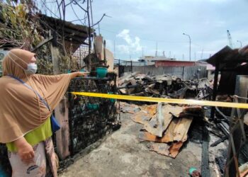 SAIDAH Mustafar menunjukkan sebahagian  rumahnya yang musnah dalam kebakaran di penempatan haram Bukit Malut, Langkawi hari ini. - UTUSAN/NUR AMALINA AZMAN