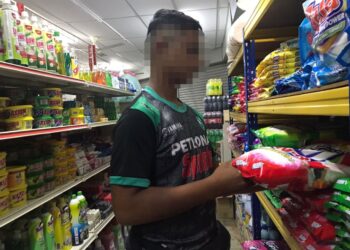 EHSAN menyambung tugas di kedai runcit selepas mengambil upah melakukan kerja-kerja di kebun sawit. – UTUSAN/LIYANA RAMLI