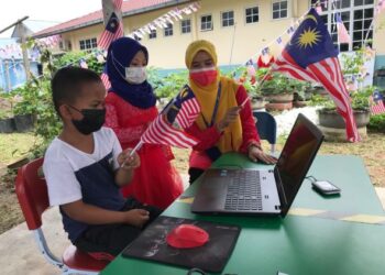 PENDIDIK dan murid Tabika serta Taska Kemas di Gua Musang, Kelantan menyambut Hari Kebangsaan secara norma baharu melalui aplikasi Zoom. - UTUSAN/AIMUNI TUAN LAH