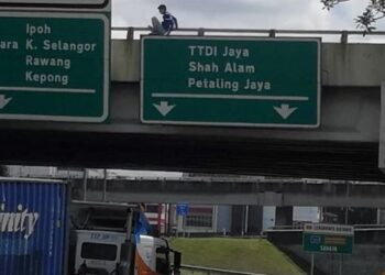 PASUKAN bomba dan polis cuba menenangkan seorang remaja lelaki berusia 20-an yang cuba bunuh diri dengan terjun dari atas jejambat Lebuhraya Koridor Guthrie di Bukit Jelutong, Shah Alam, Selangor, hari ini. - FOTO/MOHAMAD NAUFAL MOHAMAD IDRIS