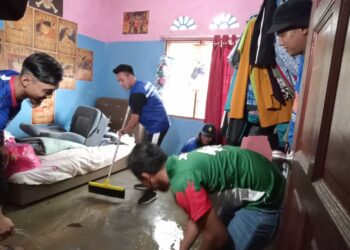 CHUA JIAN BOON membantu membersihkan kediaman seorang mangsa banjir kilat di Kampung Baru Sengkang, Kulai hari ini.