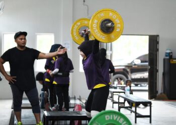 MOHD. Faiz Musa melatih anak didiknya dalam sukan angkat berat di Dewan Angkat Berat negeri di Kangar, Perlis hari ini.- UTUSAN/IZLIZAN OTHMAN