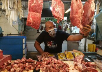 PENIAGA, Mohd. Nadzri Ahmad mengambil daging lembu untuk dipotong sebelum dijual kepada pelanggan di Pasar Awam Larkin Sentral di Johor Bahru, Johor. -UTUSAN/MOHAMAD FAIZAL HASHIM