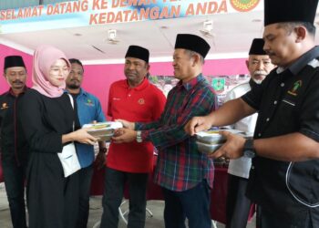 ABDUL Azeez Abdul Rahim (tengah) melihat mangsa tragedi menerima sumbangan daripada Pekida ketika Majlis Penyerahan Dana Sumbangan dan Bubur Asyura Pekida Malaysia di Dewan Terbuka Kampung Padang Empang, Kupang, hari ini.