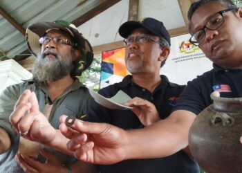 Mesran Mohd. Yusop (tengah) bersama Ruzairy Arbi (kanan) dan Dr. Dionysius Sharma menunjukkan duit syiling dan serpihan tembikar zaman Dinasti Song yang ditemui di Kuala Sungai Pahang, Pekan semalam. - UTUSAN 
/MOHD. SHAHRULANOOR ISHAK