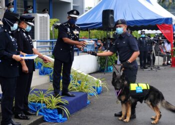 AYOB Khan Mydin Pitchay (dua kanan) menyampaikan anugerah kepada Unit Pengesan Anjing K9 yang bernama Barny bersama pengendalinya, Lans Koperal Calvin Maluni sempena Sambutan Hari Polis ke 214 Peringkat Negeri Johor di IPK Johor. -UTUSAN/RAJA JAAFAR ALI