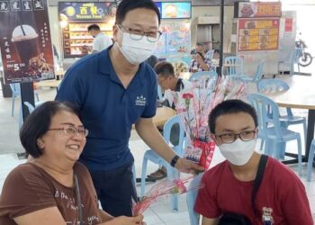 DOMINIC Lau Hoe Chai (tengah) ketika menyerahkan kuntuman bunga sempena sambutan Hari Ibu di Icon City, Bukit Mertajam, Pulau Pinang, hari ini.