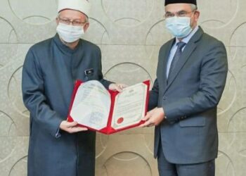 DR. ZULKIFLI MOHAMAD AL-BAKRI (kiri) menyerahkan surat pelantikan Pengerusi MAIWP yang baharu kepada Dr. Mohd, Daud Bakar di Putrajaya, semalam.