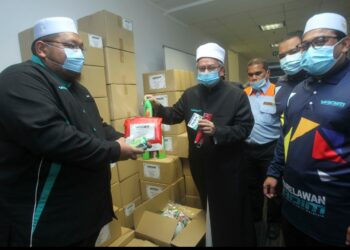 DR. Zulkifli Mohamad Al-Bakri (tengah) melihat barangan sumbangan pada Majlis Pelancaran Bilik Gerakan Misi Bantuan Bencana Banjir di pejabat Yadim, Putrajaya hari ini. Yang  hadir sama, Pengerusi Yadim, Nasruddin Hassan (kanan). - UTUSAN/FAISOL MUSTAFA