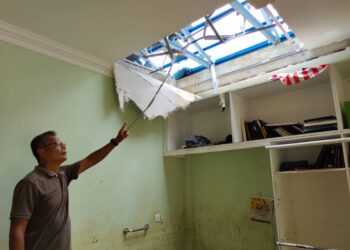 MOHD. Fauzi Sharib menunjukkan bahagian syiling yang dibuka oleh belia kampung bagi mengangkat dan meletak warga emas terlantar sementara menunggu bantuan sebenar tiba di Kampung Kemin Tanjung, awal pagi tadi. - UTUSAN/NOR AINNA HAMZAH