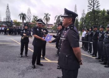 MUHAMAD Zaki (kiri) menyampaikan sijil penghargaan kepada pegawainya di IPK Kota Bharu, Kelantan hari ini.UTUSAN/ROHANA MOHD.NAWI