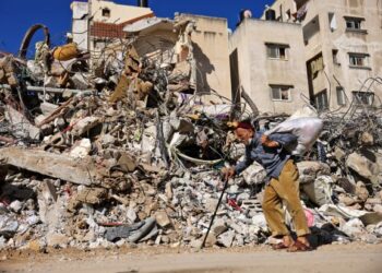 SEORANG lelaki warga emas berjalan melalui bangunan runtuh akibat serangan udara Zionis di Gaza City, Palestin. - AFP