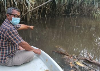 PENDUDUK menunjukkan keadaan air Sungai Pengkalan Ranggon yang bertukar menjadi keruh dan hitam di Kemaman, hari ini. - NIK NUR IZZATUL HAZWANI NIK ADNAN