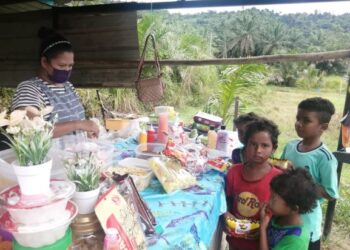 SITI Rohana Mat Rahim melayan anak-anak Orang Asli Semaq Beri yang datang membeli makanan di gerainya yang terletak di Kampung Oraang Asli Sungai Berua di Hulu Terengganu, baru-baru ini.