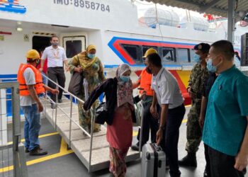 TAN Teik Cheng (kanan) menyambut penumpang yang menggunakan feri bot laju pada hari pertama beroperasi di Terminal Swettenham Pier Cruise, Georgetown, Pulau Pinang hari ini.