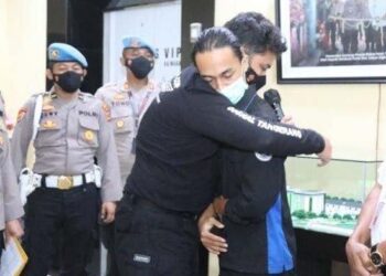 ANGGOTA polis yang didakwa memukul Fariz memeluk pelajar itu ketika memohon maaf atas perbuatannya di Tangerang, Indonesia. - AGENSI