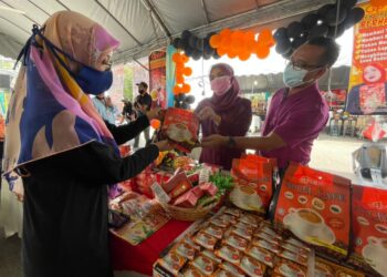 SUHAIDA SAAD melayan pelanggan yang berkunjung ke gerainya sempena Karnival Food Republik yang berlangsung di pekarangan tempat letak kereta Pasaraya Lotuss, Seberang Jaya, Pulau Pinang semalam.