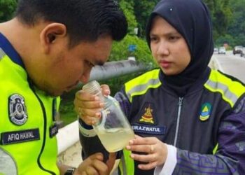 PETUGAS LUAS sedang menghidu bau dikenal pasti diesel yang menyebabkan pencemaran air Sungai Semenih di muka sauk LRA Sungai Semenyih, tengah hari tadi.