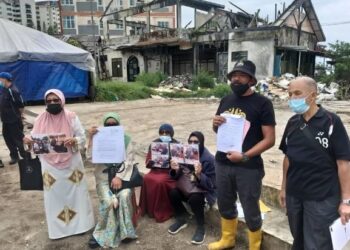 PARA peniaga berkumpul di hadapan tapak gerai mereka yang dirobohkan di Kea Farm di Cameron Highlands hari ini. - FOTO/SAYED HESHAM IDRIS