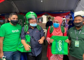 Menteri Pembangunan Luar Bandar, Datuk Dr. Abd. Latiff Ahmad (dua dari kiri) bersama Ahli Dewan Undangan Negeri (ADUN) Endau, Alwiyah Talib memakai topi keledar dan beg GrabFood sempena perasmian Karnival Mini DesaMall@KPLB di Pusat Komuniti Desa Air Merah, Mersing, semalam.