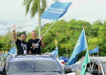 MOHD. HAFIZAL Mohamed Shah atau mesra dipanggil Tok Hafizal (kiri) melambai tangan ketika mengadakan tinjauan mesra di Pasar Malam Batu 3 di Kuantan, Pahang. - FOTO/SHAIKH AHMAD RAZIF