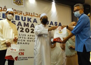 MOHD. Nassuruddin Daud (dua kiri) menyampaikan sumbangan kepada pengamal media Kelantan pada Majlis Berbuka Puasa Bersama UPKN di Kota Bharu, Kelantan, semalam. - UTUSAN/YATIMIN ABDULLAH