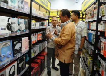 HASNI Mohammad meninjau dan melihat aksesori selepas merasmikan pembukaan cawangan baharu Al-Ikhlas Gadjet di Larkin Sentral, Johor Bahru, hari ini. - FOTO/RAJA JAAFAR ALI