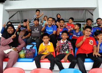 MOHD. HELMY ABD. LATIF bersama-sama golongan remaja dan  penduduk kampung menyaksikan perlawanan bola sepak di Stadium Mini SK Parit Nawi, Muar.